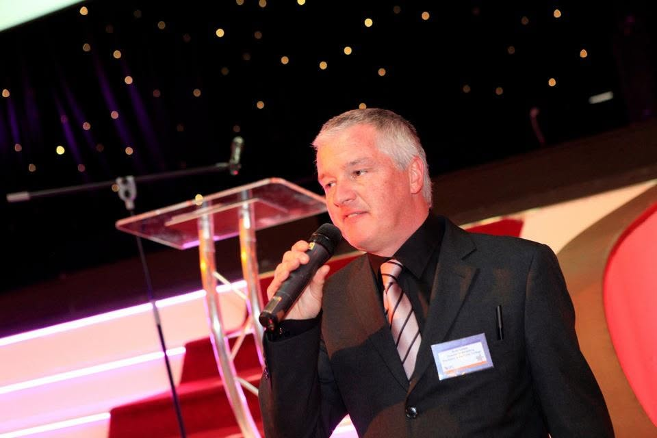Andy Iredale speaking into a microphone at an event
